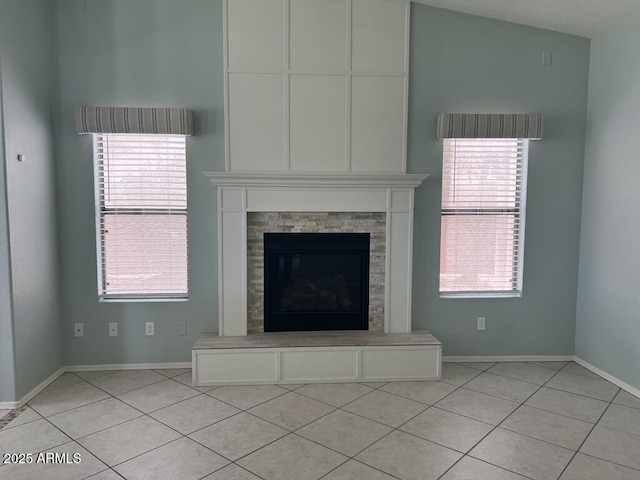 3876 Camino Del Vara, Sierra Vista, AZ 85650 - unfurnished living room featuring light tile patterned floors, a glass covered fireplace, and baseboards