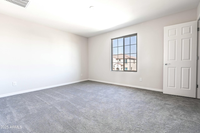 empty room featuring baseboards, visible vents, and dark colored carpet