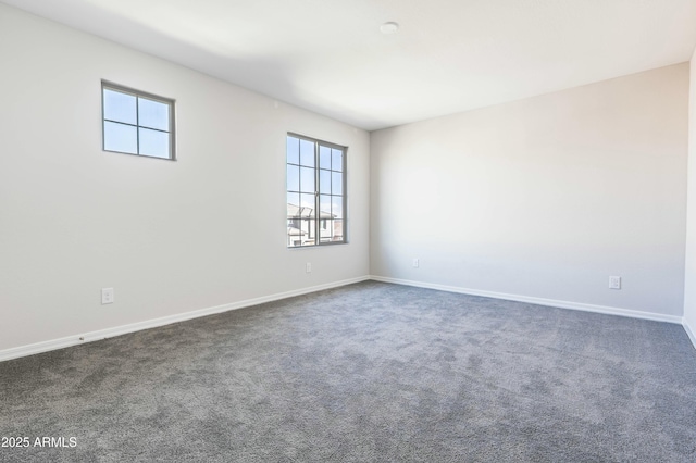 empty room with baseboards and dark carpet