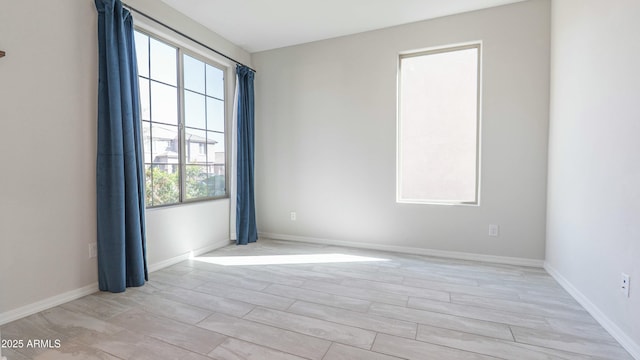 unfurnished room with light wood-style flooring and baseboards