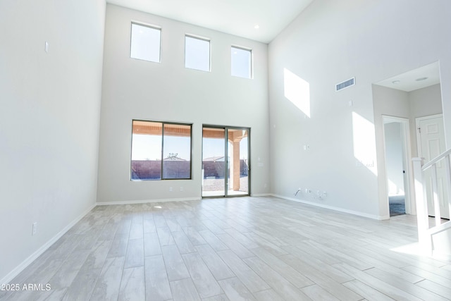 unfurnished living room with light wood-style flooring, baseboards, and visible vents