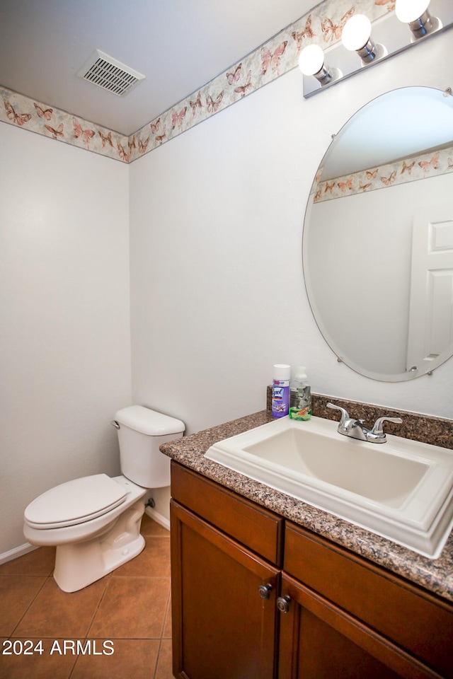 bathroom with toilet, tile floors, and vanity