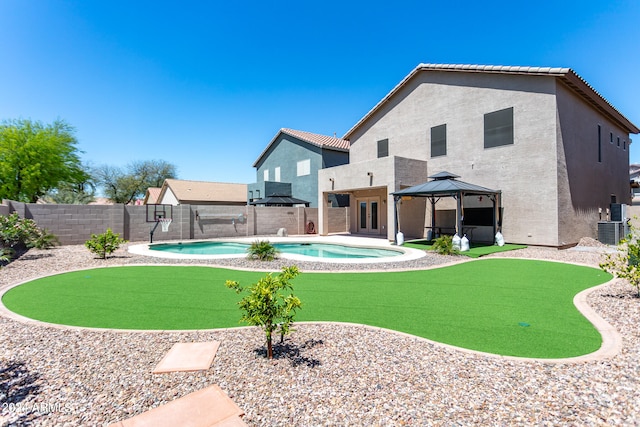 exterior space featuring central AC unit, an outdoor hot tub, and a gazebo