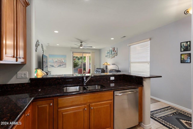 kitchen with sink, stainless steel dishwasher, ceiling fan, and dark stone countertops