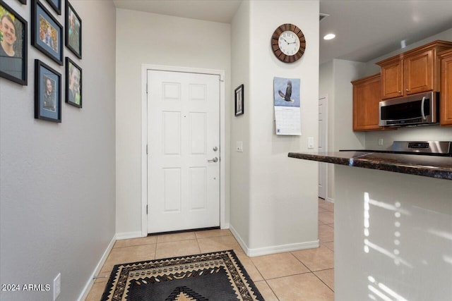 kitchen with light tile patterned flooring and dark stone counters