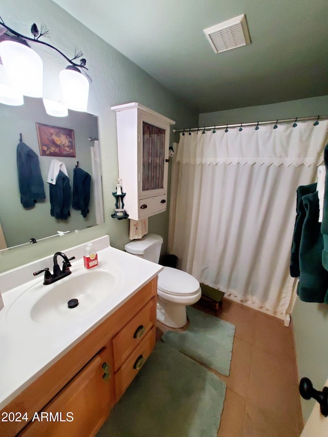 bathroom featuring curtained shower, tile patterned flooring, vanity, and toilet