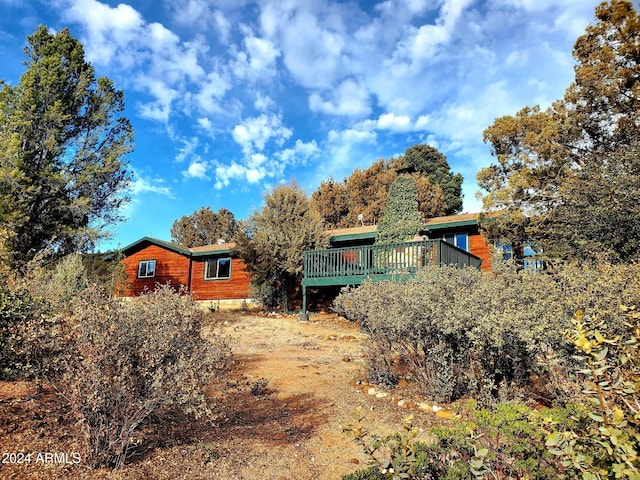 rear view of house featuring a wooden deck