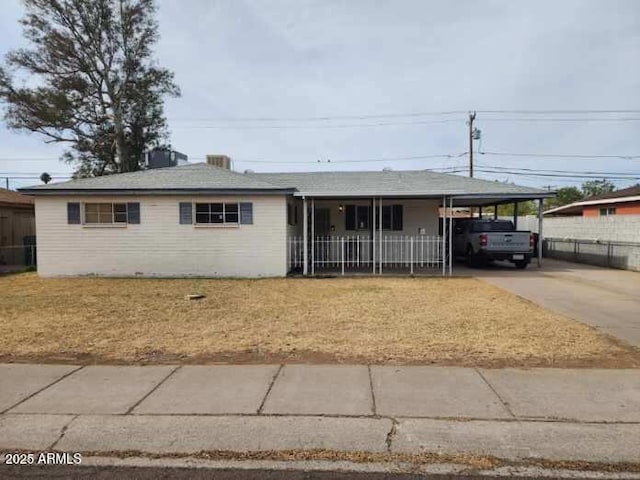 ranch-style house with a carport, a front yard, fence, and driveway