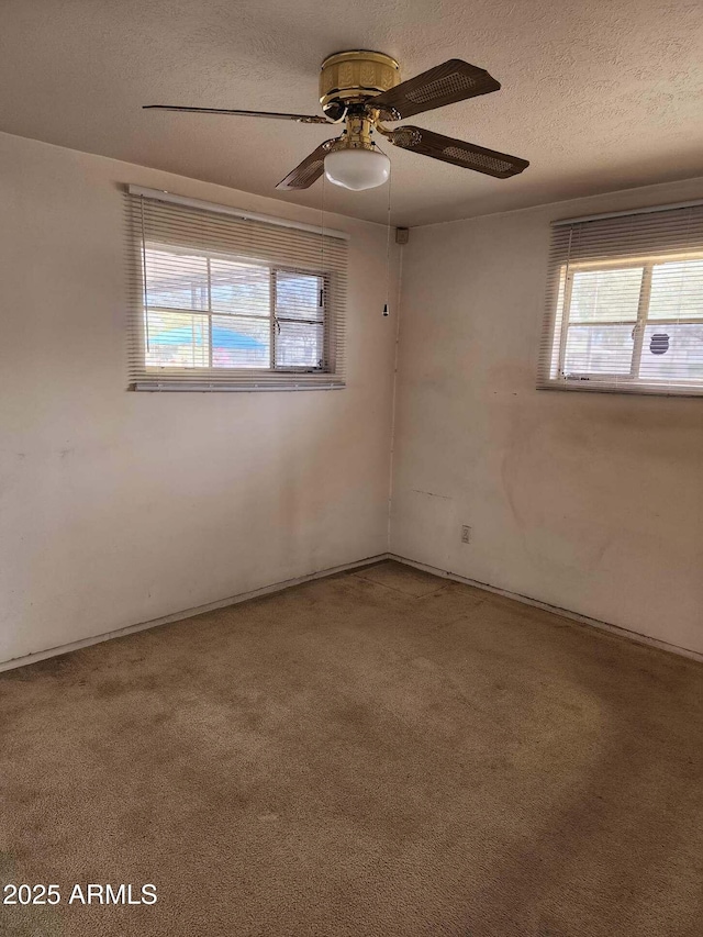 carpeted spare room with a textured ceiling and ceiling fan