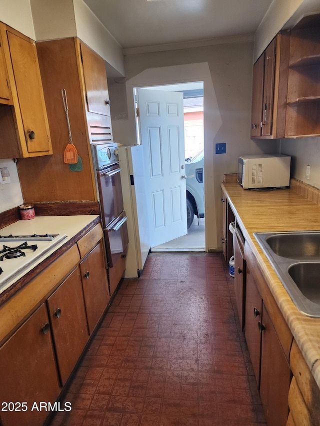 kitchen with brown cabinets, light countertops, oven, and open shelves