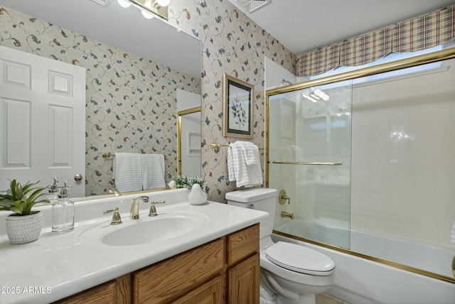 full bathroom with bath / shower combo with glass door, vanity, and toilet