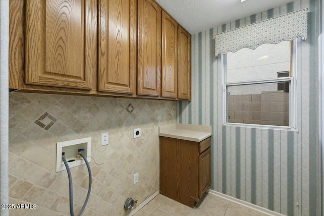 laundry area with light tile patterned flooring, cabinets, a textured ceiling, washer hookup, and hookup for an electric dryer