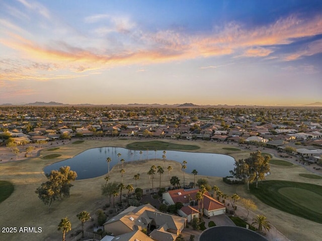 aerial view at dusk featuring a water view and a residential view