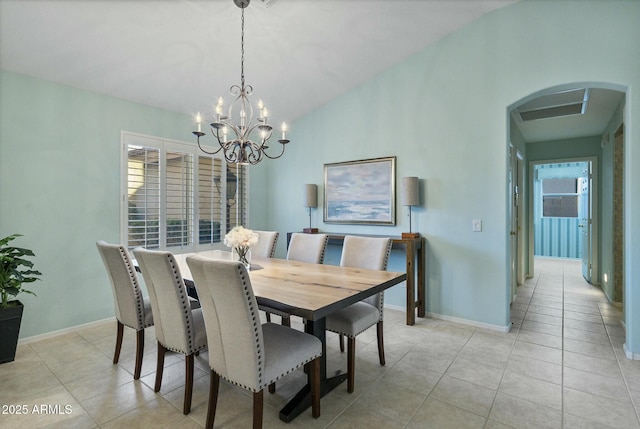 dining area featuring light tile patterned flooring, a chandelier, and vaulted ceiling