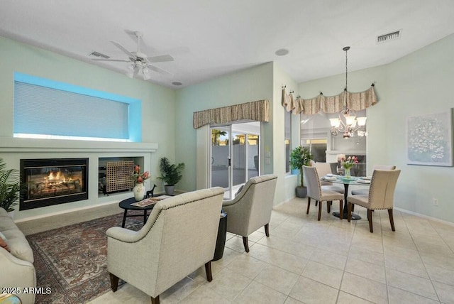 living room featuring ceiling fan with notable chandelier and light tile patterned floors