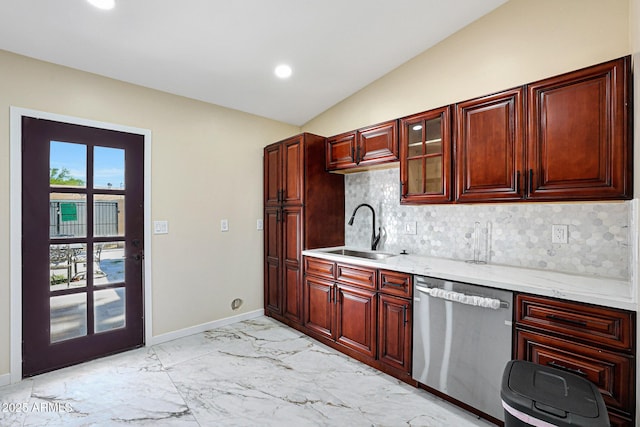 kitchen with tasteful backsplash, stainless steel dishwasher, a sink, and vaulted ceiling