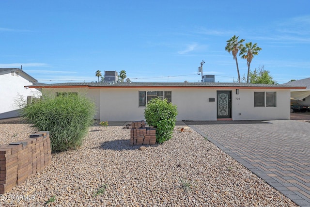 back of house featuring stucco siding and central AC