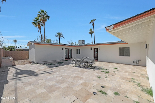 rear view of house featuring french doors, a patio area, stucco siding, and fence