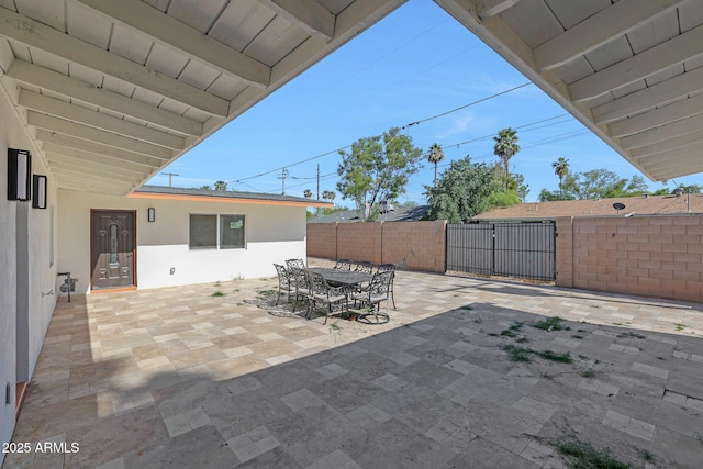 view of patio / terrace featuring outdoor dining space, fence, and a gate
