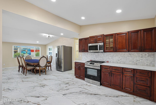 kitchen with appliances with stainless steel finishes, recessed lighting, dark brown cabinets, lofted ceiling, and decorative backsplash