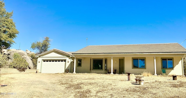 ranch-style house with stucco siding, driveway, a tile roof, and a garage