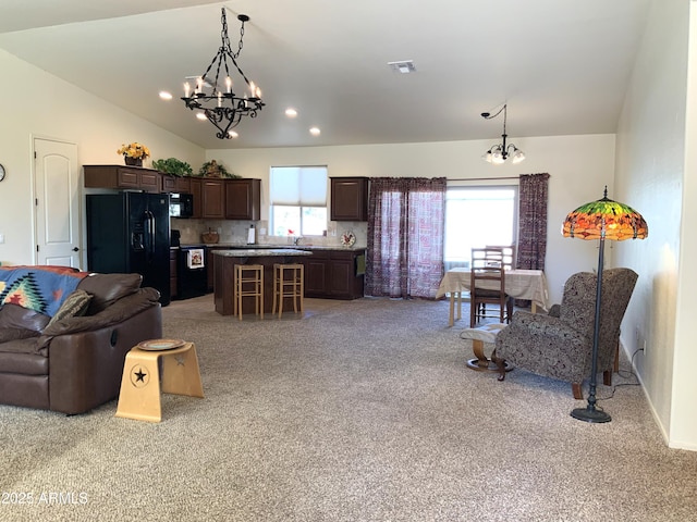 living area featuring light carpet, recessed lighting, an inviting chandelier, and vaulted ceiling