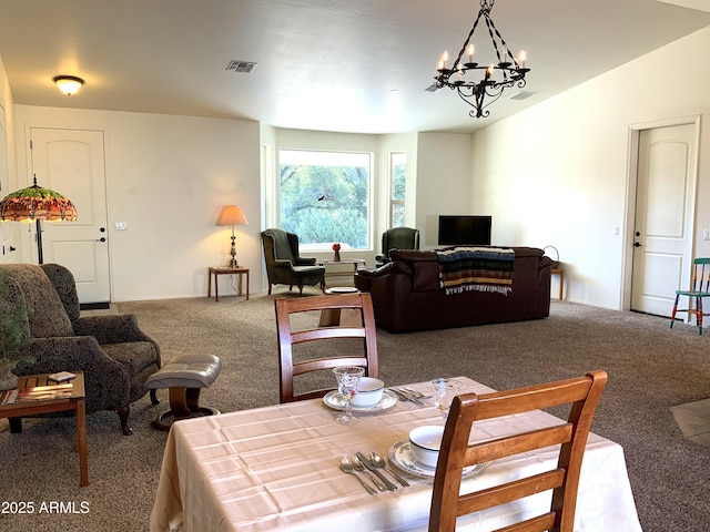 dining room with a notable chandelier, carpet flooring, visible vents, and vaulted ceiling