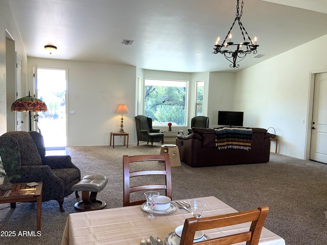 carpeted living room featuring visible vents, a notable chandelier, and a healthy amount of sunlight