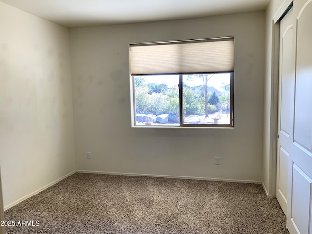 unfurnished bedroom with a closet, carpet floors, and baseboards