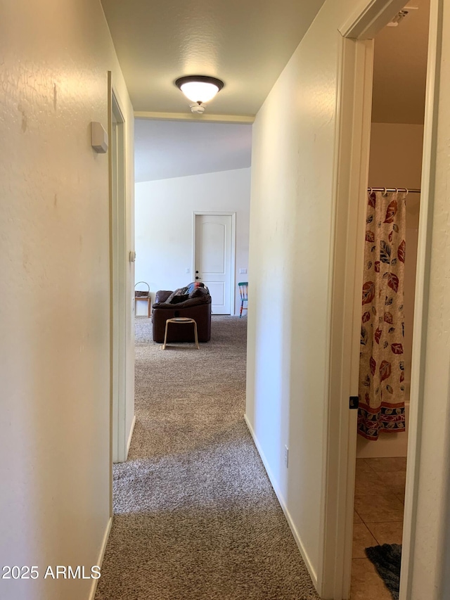 hall with baseboards and carpet floors