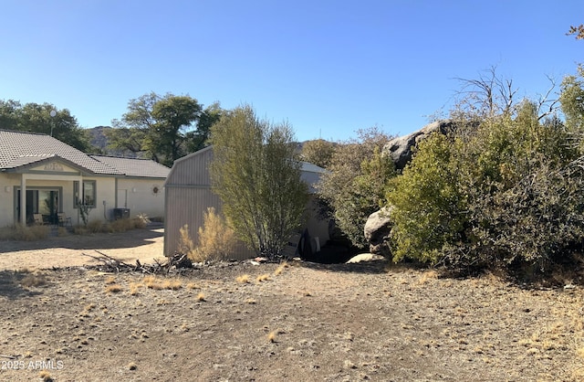 view of property exterior featuring an outdoor structure and a shed