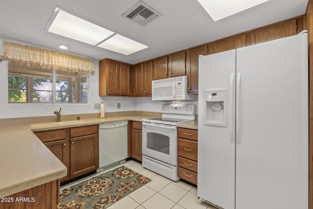 kitchen with sink, white appliances, and light tile patterned flooring