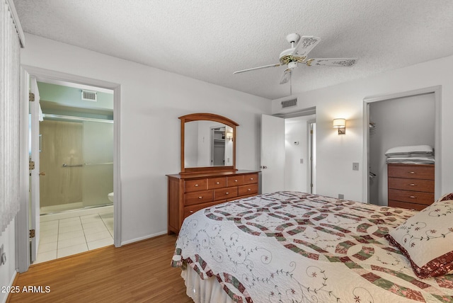 bedroom with ceiling fan, light wood-type flooring, a closet, and a textured ceiling