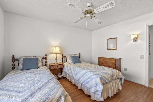 bedroom featuring a textured ceiling, ceiling fan, and light hardwood / wood-style flooring