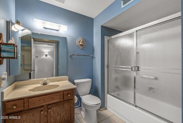 full bathroom with combined bath / shower with glass door, vanity, tile patterned flooring, and toilet