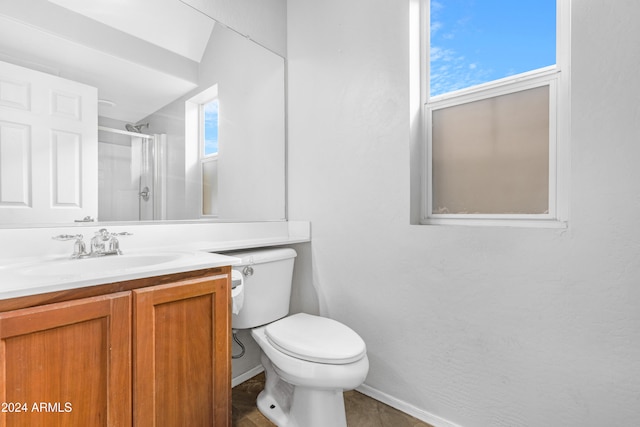 bathroom featuring a wealth of natural light, a shower with shower door, vanity, and toilet