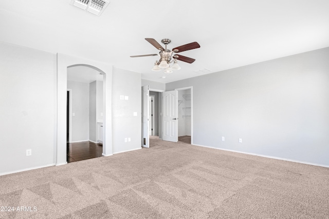 interior space with carpet flooring, ceiling fan, a walk in closet, and a closet