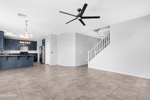 unfurnished living room with ceiling fan with notable chandelier and sink