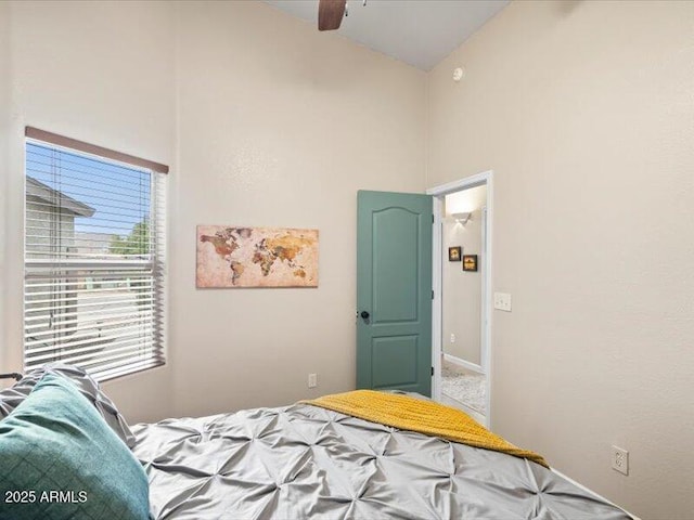 bedroom with baseboards, ceiling fan, and high vaulted ceiling