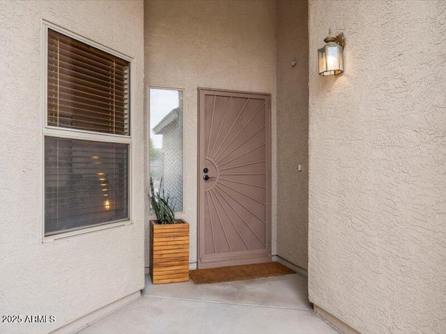 doorway to property featuring stucco siding
