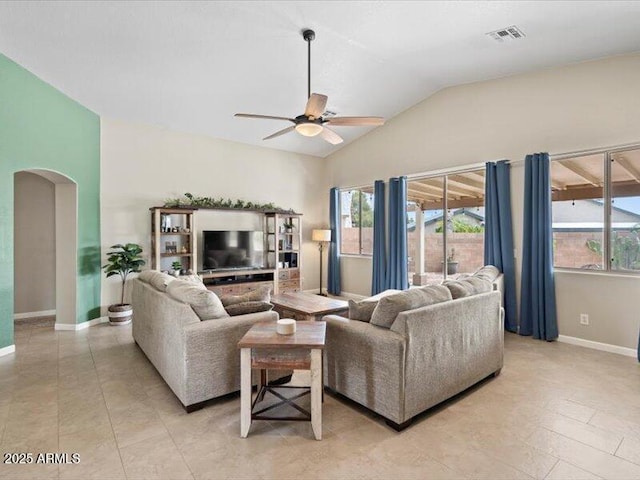 living room with ceiling fan, visible vents, arched walkways, vaulted ceiling, and baseboards