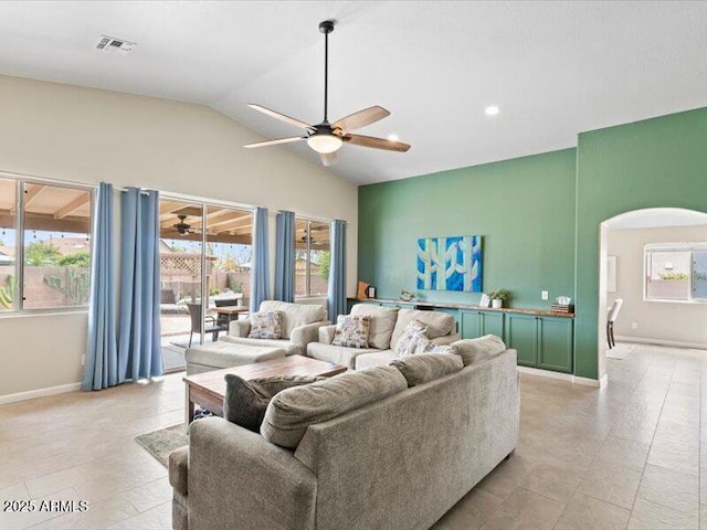 living area with a ceiling fan, visible vents, a healthy amount of sunlight, and vaulted ceiling