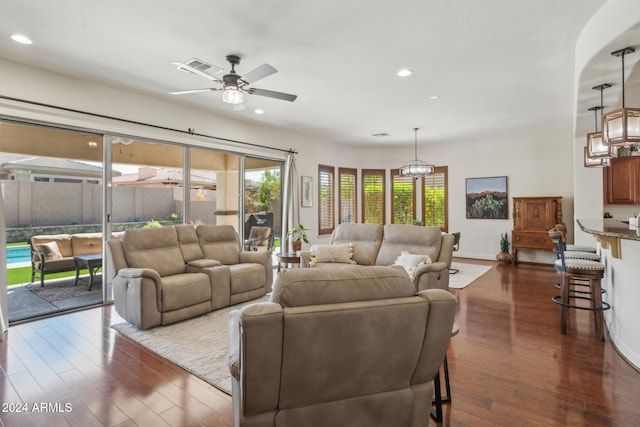 living room with ceiling fan and dark hardwood / wood-style flooring