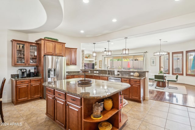 kitchen featuring pendant lighting, stainless steel appliances, plenty of natural light, and a center island