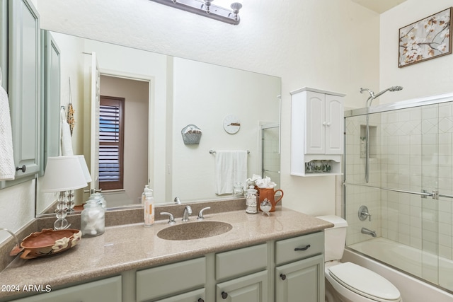 full bathroom featuring vanity, toilet, and bath / shower combo with glass door