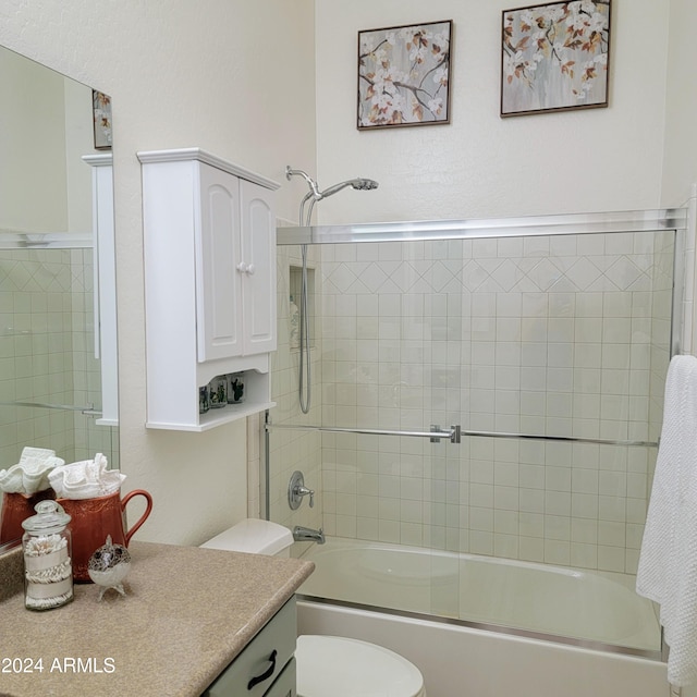 full bathroom featuring enclosed tub / shower combo, vanity, and toilet