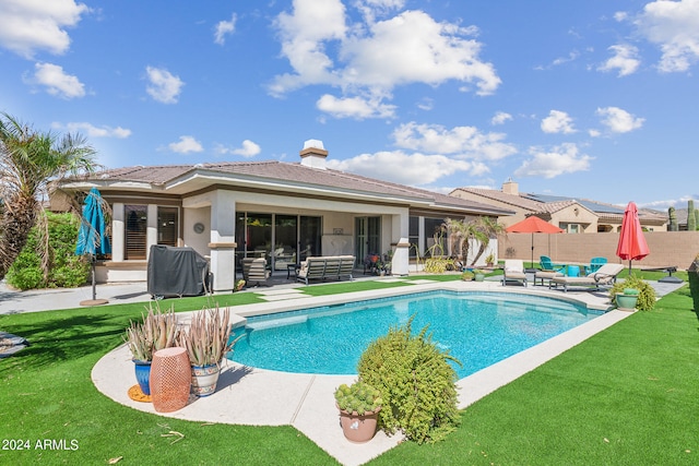 view of pool with a patio and a lawn