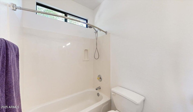 bathroom with tiled shower / bath combo and toilet