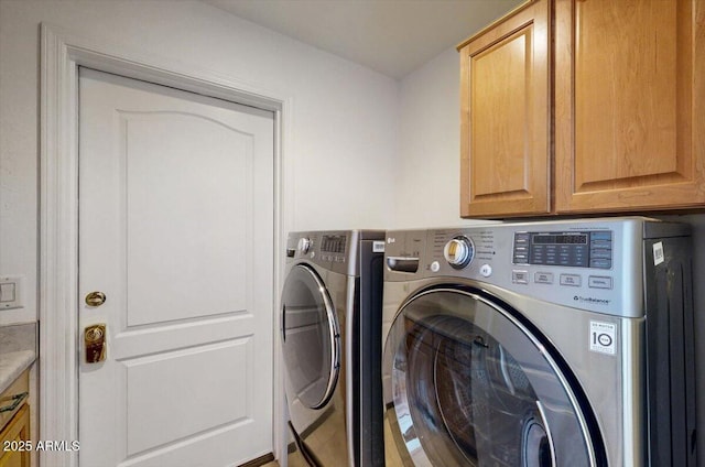 laundry room featuring cabinets and washing machine and dryer