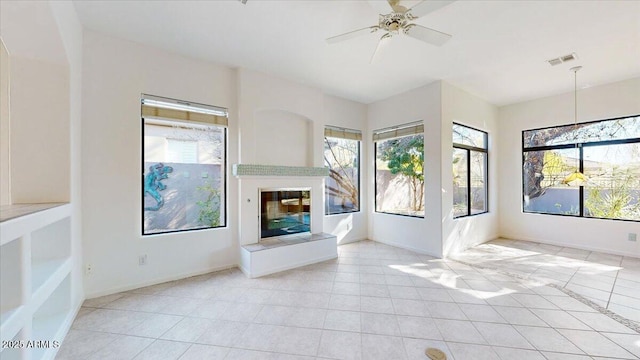 unfurnished living room featuring light tile patterned floors and ceiling fan